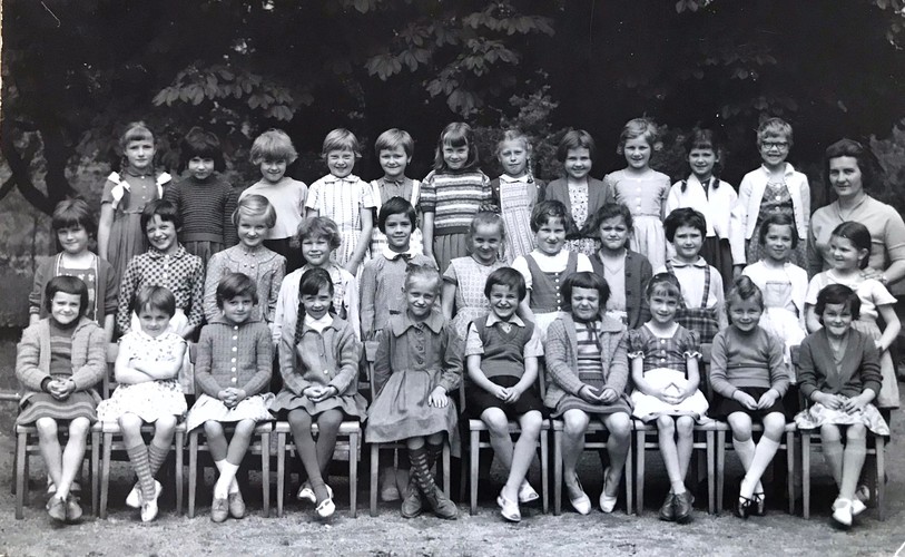 Klassenfoto in Schwarz-Weiss der 1. Klasse von Renate Meister. In drei Reihen stehen oder sitzen 32 Mädchen für ein Klassenfoto. Renate Meister steht in der zweiten Reihe rechts, direkt vor ihrer Lehrerin.