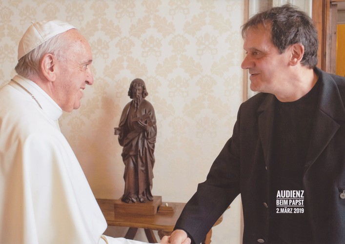Foto von Mario Delfino und Papst Franziskus händeschüttelnd.